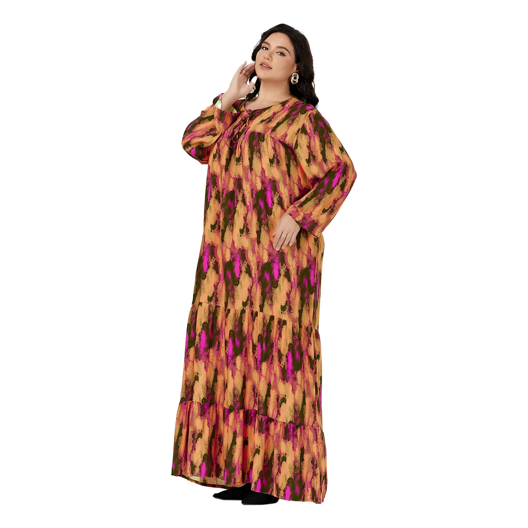 Une femme porte une robe longue à manches longues avec un motif orange, rose et vert. La robe est à volants et a un décolleté rond.