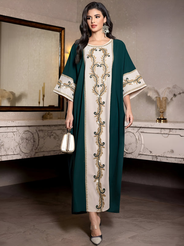 Une femme porte une robe longue verte avec des broderies dorées. La robe a une coupe ample et est parfaite pour les occasions spéciales. La robe est disponible en plusieurs couleurs et tailles.