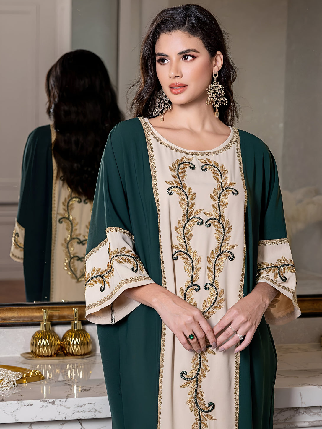 Une femme porte une abaya verte foncée avec des détails dorés et un motif de feuilles.