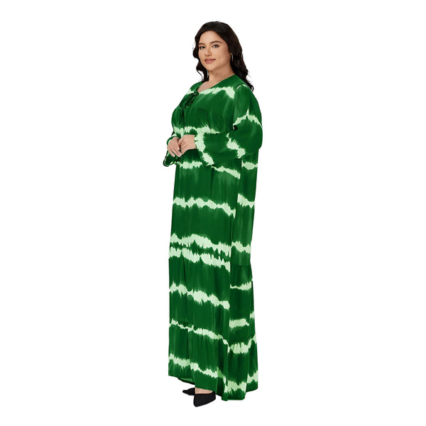 Une femme portant une robe longue verte à manches longues avec un motif tie-dye. La robe est ample et fluide, idéale pour les occasions spéciales ou le quotidien.