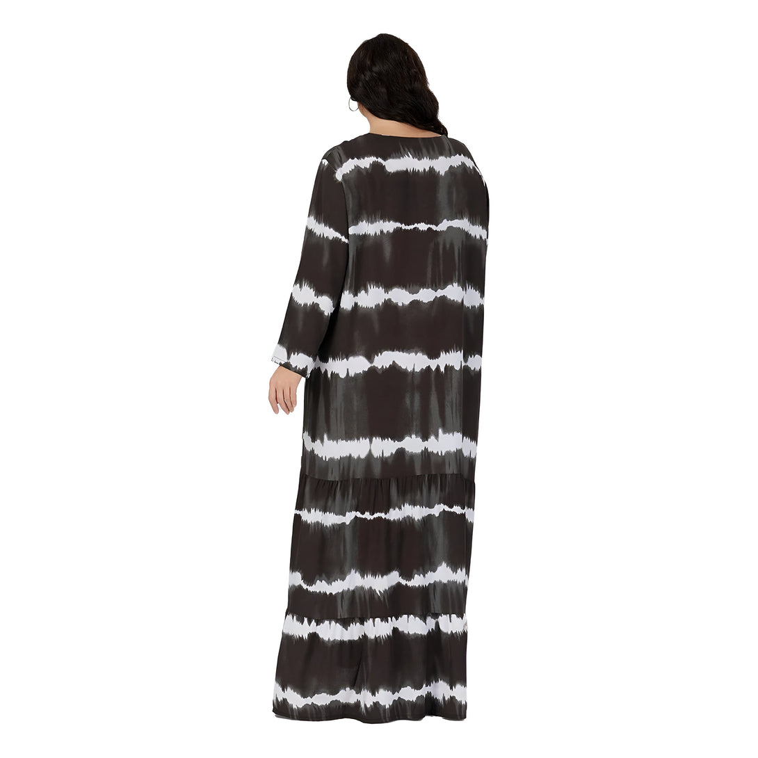 Une robe longue à manches longues avec un motif tie-dye noir et blanc. La robe est plissée à l'ourlet.