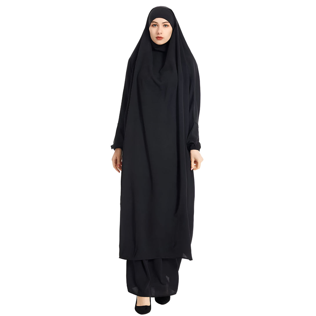 Une femme portant une abaya noire longue et ample avec un hijab assorti. La robe est élégante et confortable, idéale pour les occasions spéciales ou la vie quotidienne.