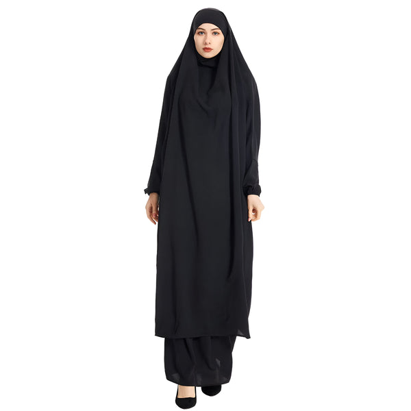 Une femme portant une abaya noire longue et ample avec un hijab assorti. La robe est élégante et confortable, idéale pour les occasions spéciales ou la vie quotidienne.