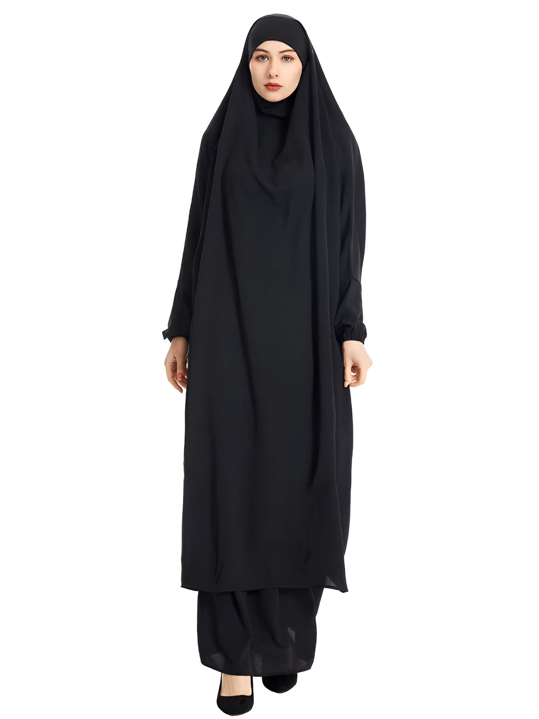Une femme portant une abaya noire, un vêtement traditionnel musulman pour les femmes. L'abaya est une robe ample et longue qui couvre tout le corps, sauf le visage et les mains. Elle est souvent portée avec un hijab, un foulard qui couvre la tête et le cou.