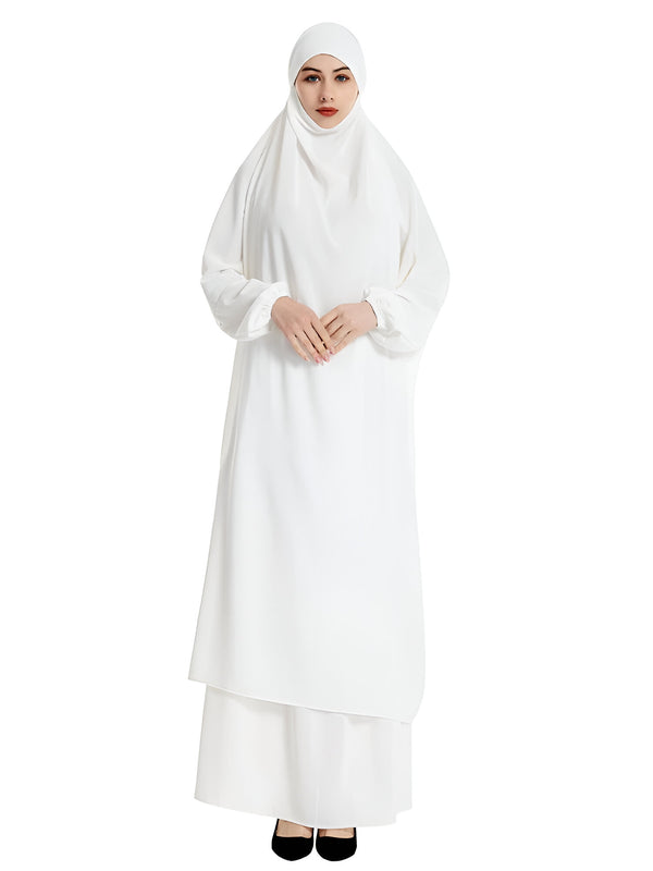 Une femme portant une robe blanche longue et ample avec un hijab assorti. La robe est parfaite pour la prière et d'autres occasions spéciales.