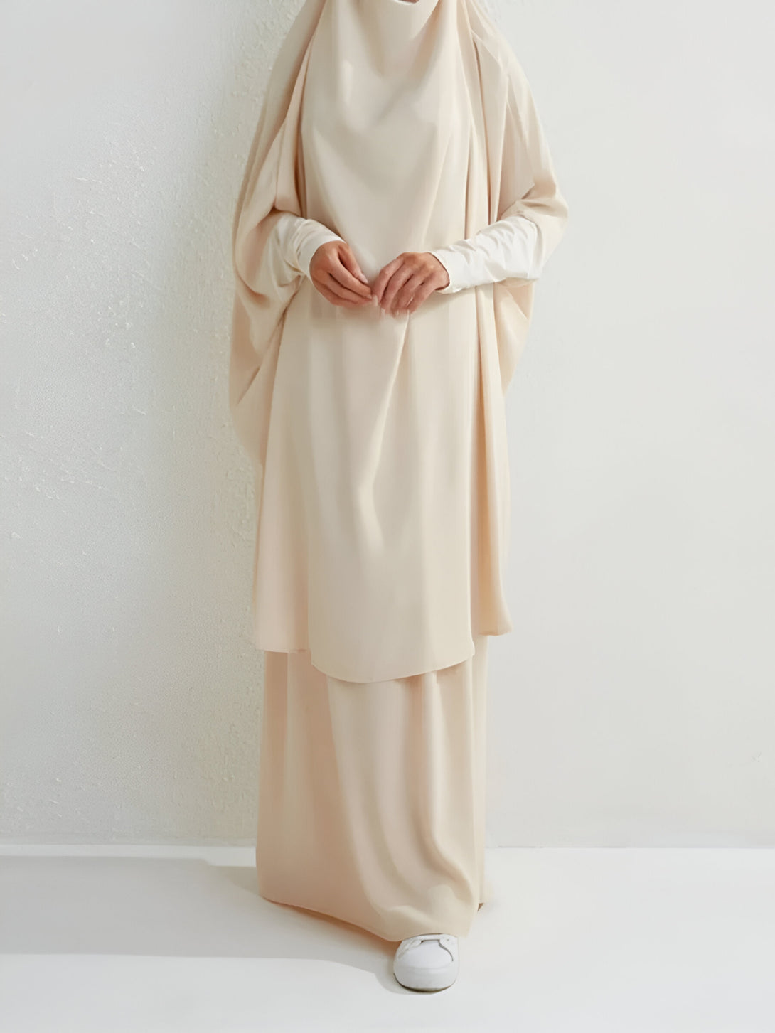 Une femme portant une abaya beige élégante et ample, idéale pour les occasions spéciales ou le quotidien.