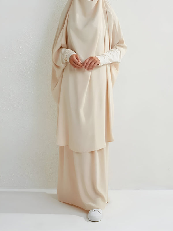 Une femme portant une abaya beige élégante et ample, idéale pour les occasions spéciales ou le quotidien.