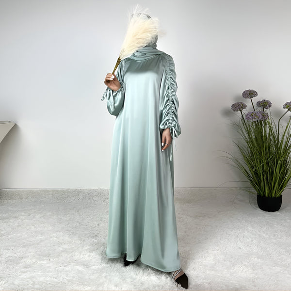 Robe longue en satin vert menthe avec manches bouffantes et un col haut.  Parfaite pour les occasions spéciales.
