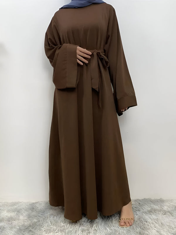 Robe longue marron à manches longues et ceinture pour femme musulmane. La robe est élégante et confortable, idéale pour les occasions spéciales ou au quotidien.