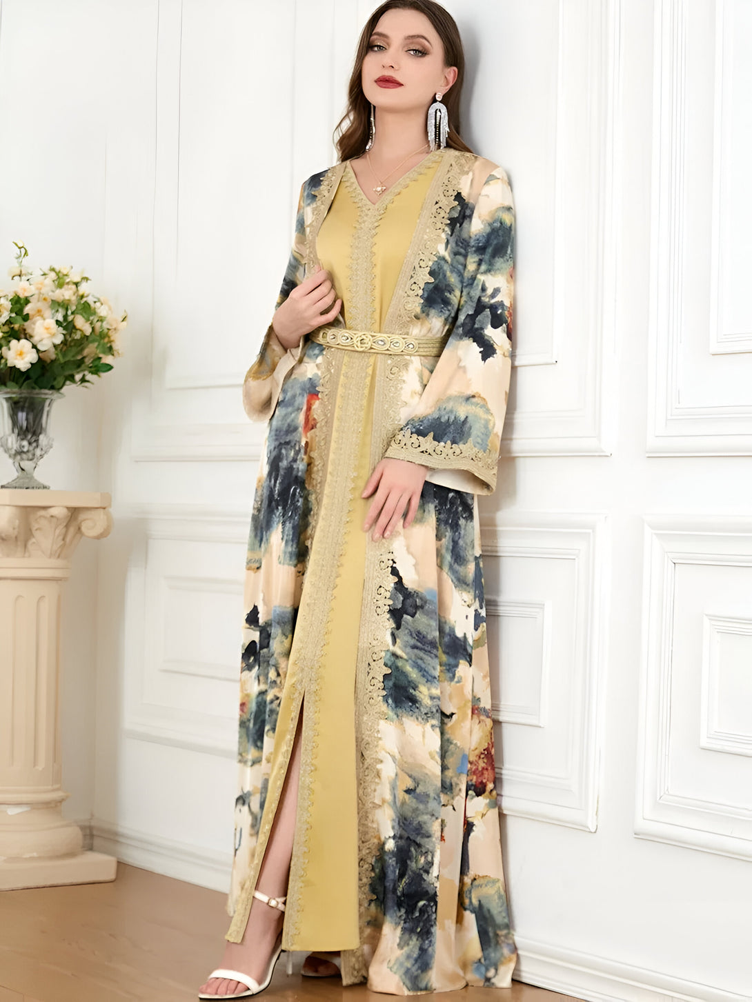 Une femme élégante porte une robe longue musulmane jaune avec des détails en dentelle. La robe présente un imprimé abstrait bleu et blanc.
