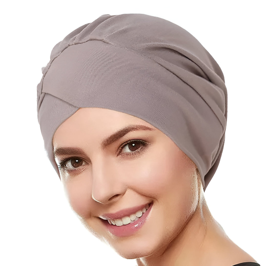 Une femme souriante portant un turban gris en tissu doux, idéal pour les femmes musulmanes.