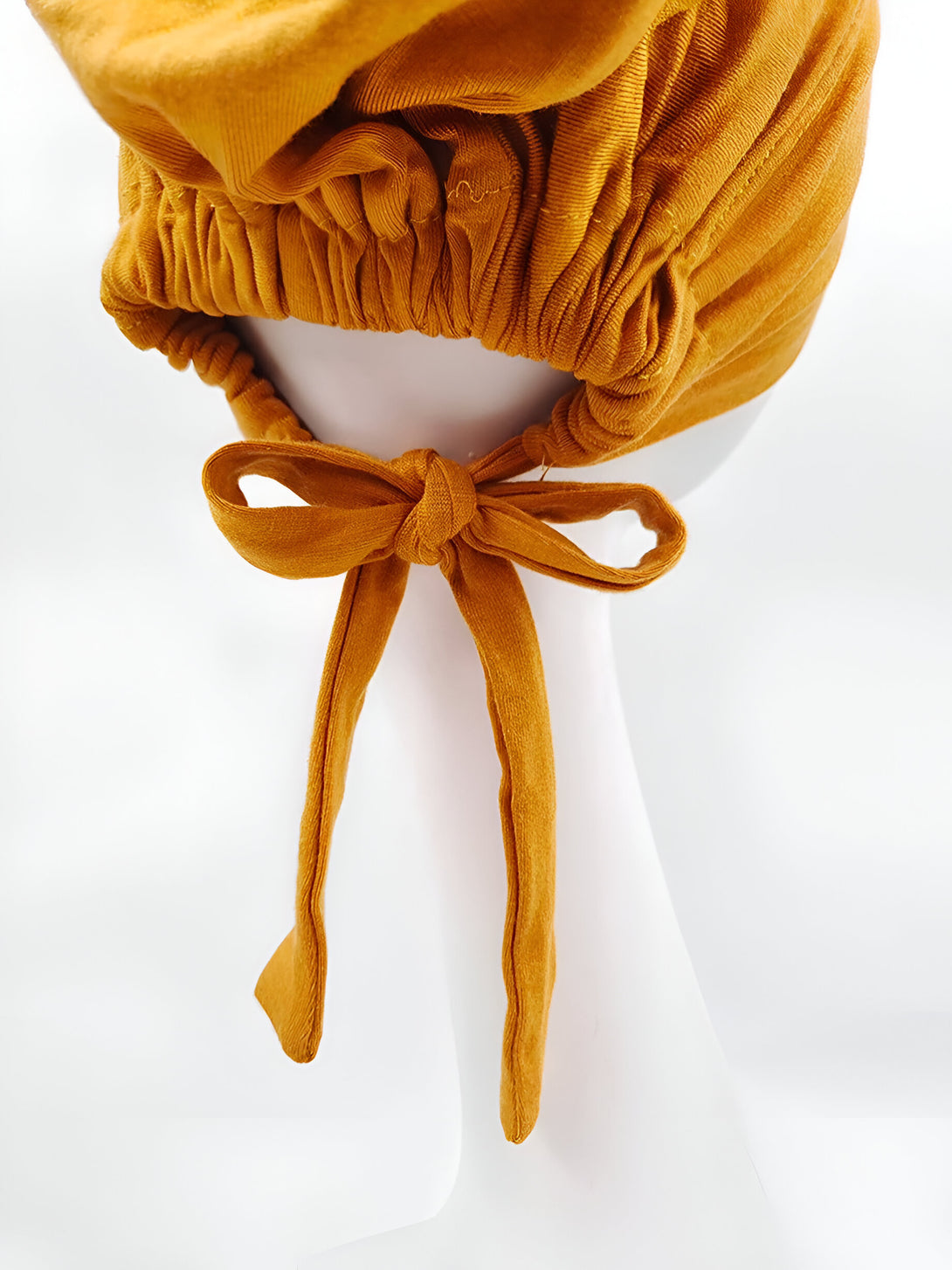 Chapeau musulman en coton de couleur moutarde avec un nœud à l'arrière.  Ce chapeau est idéal pour les femmes musulmanes qui souhaitent couvrir leurs cheveux avec style.
