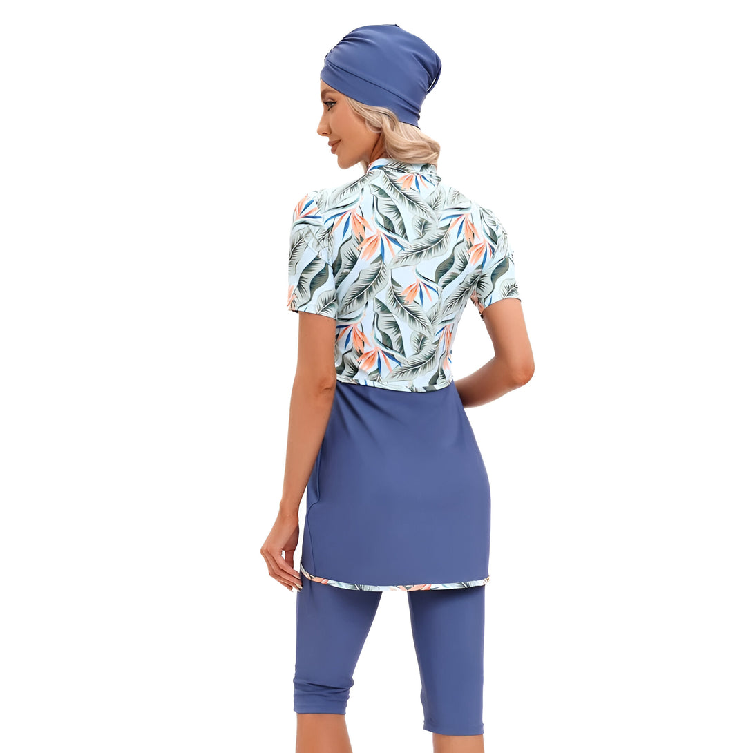 Une femme portant un maillot de bain musulman bleu avec un motif tropical et un hijab bleu.
