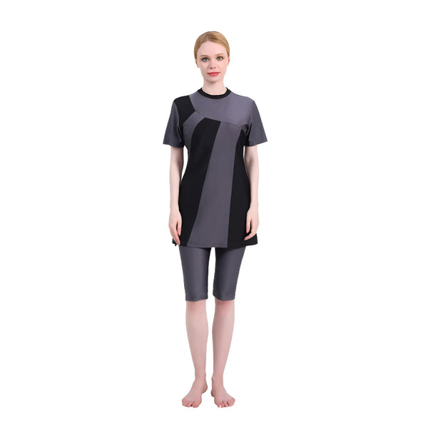 Une femme portant un maillot de bain musulman gris et noir avec des manches courtes.  Le maillot de bain est à la fois élégant et modeste, parfait pour la natation ou la plage.