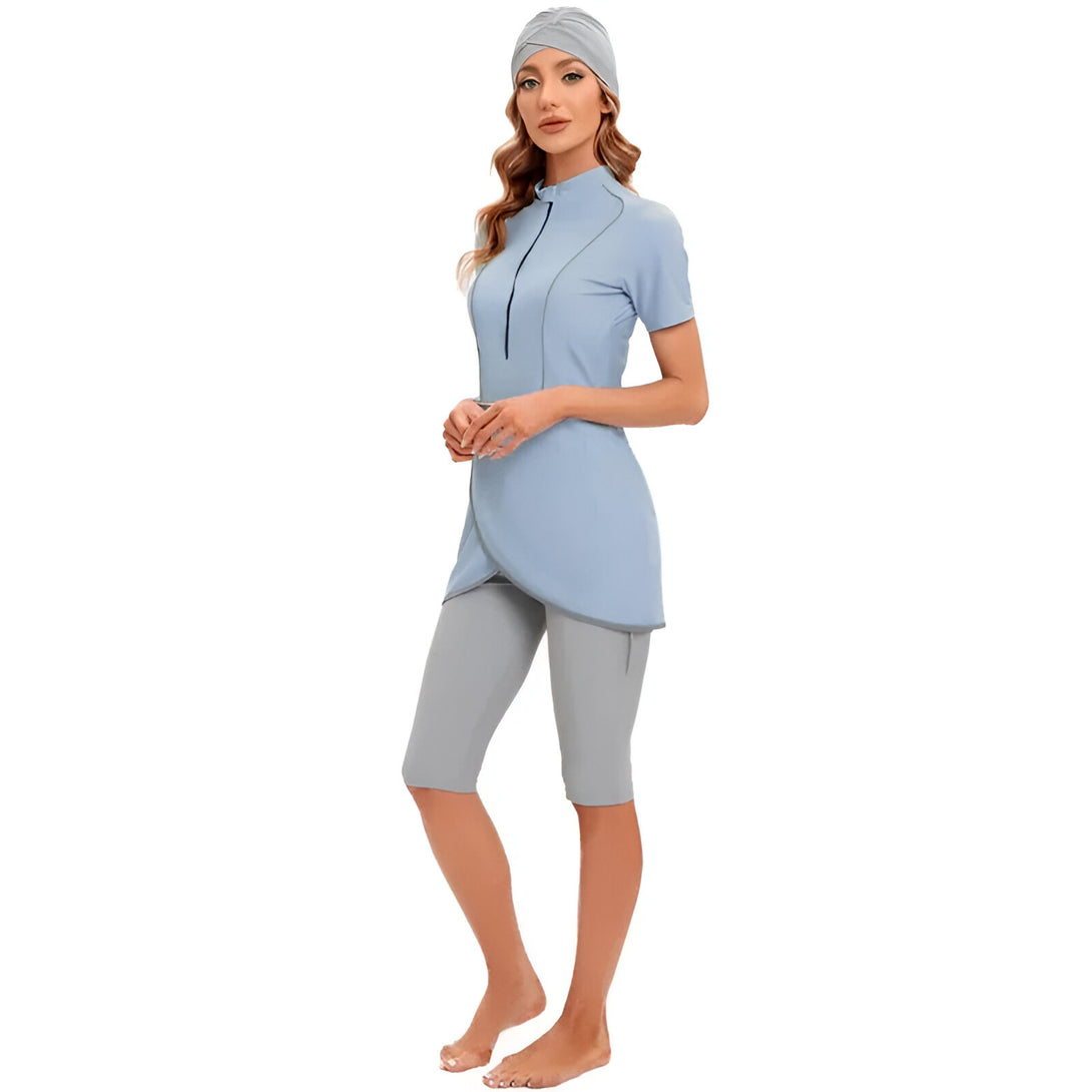 Une femme porte un maillot de bain musulman bleu clair avec un pantalon assorti et un foulard.