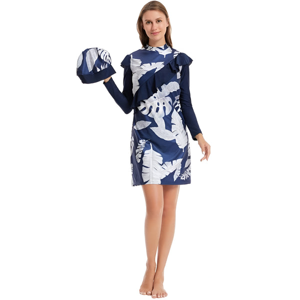 Une femme portant une robe de bain musulmane bleu marine avec un motif de feuilles blanches et un bonnet assorti.