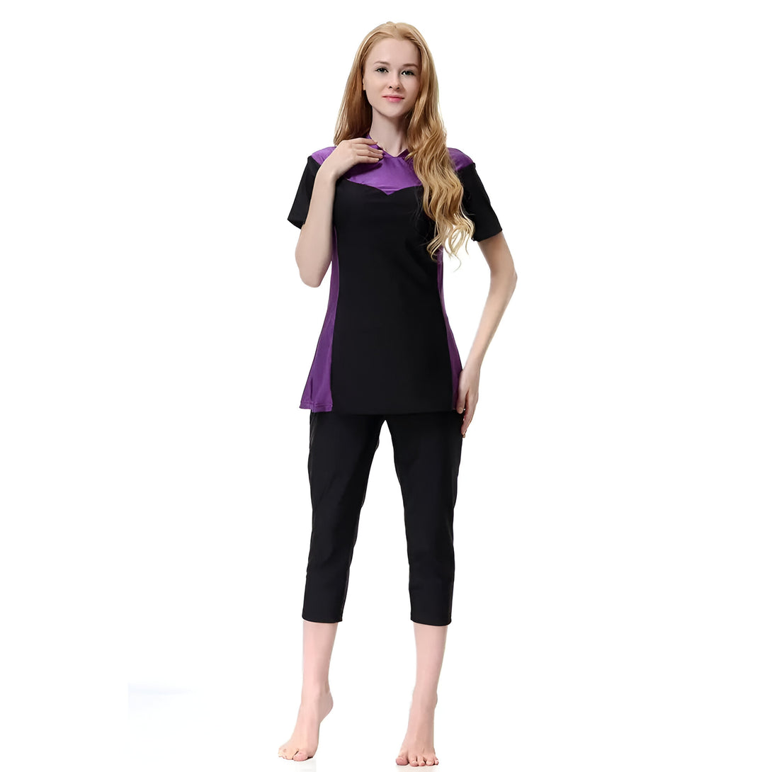 Une femme portant un maillot de bain musulman noir et violet avec des manches courtes.