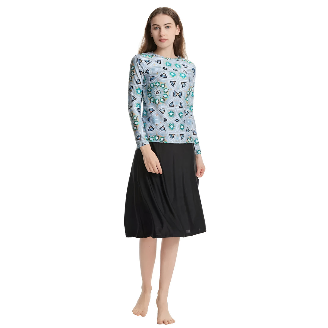 Une femme portant un chemisier à manches longues imprimé de motifs géométriques bleus et une jupe noire. Vêtements musulmans pour femmes.