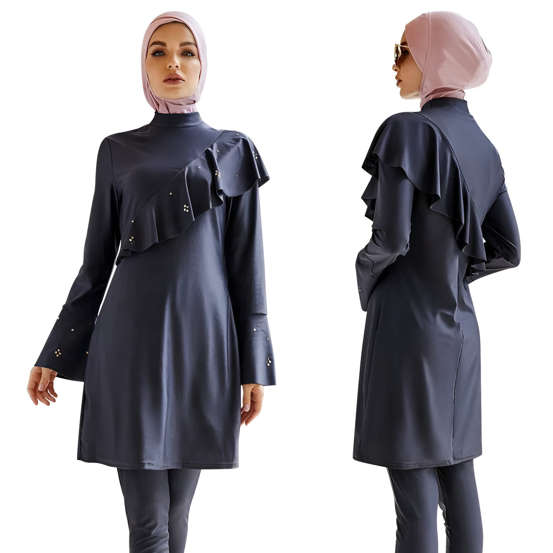 Maillot de bain musulman pour femme avec manches longues, jupe et pantalon. Le maillot de bain est bleu foncé avec des détails dorés et un col montant.