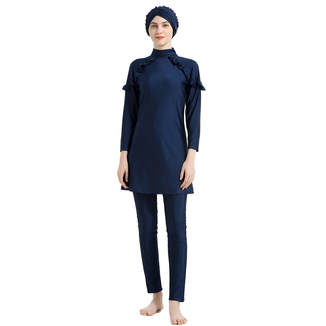 Une femme portant un maillot de bain musulman bleu foncé avec un hijab assorti. Le maillot de bain a des manches longues et des jambes longues, et la femme porte un hijab sur la tête.