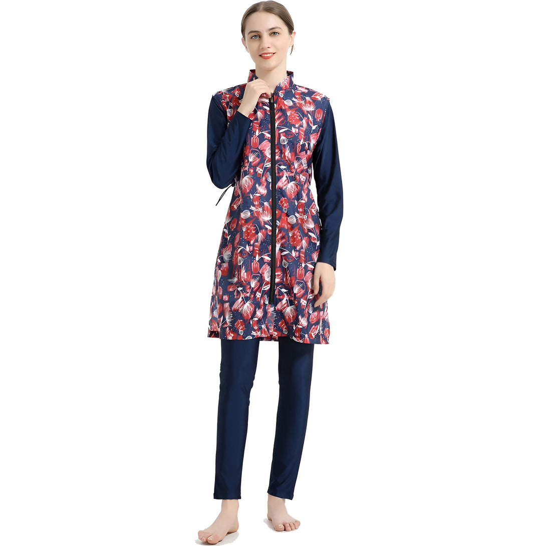 Une femme portant un maillot de bain musulman bleu marine à fleurs rouges. Le maillot de bain a une fermeture éclair sur le devant et des manches longues.