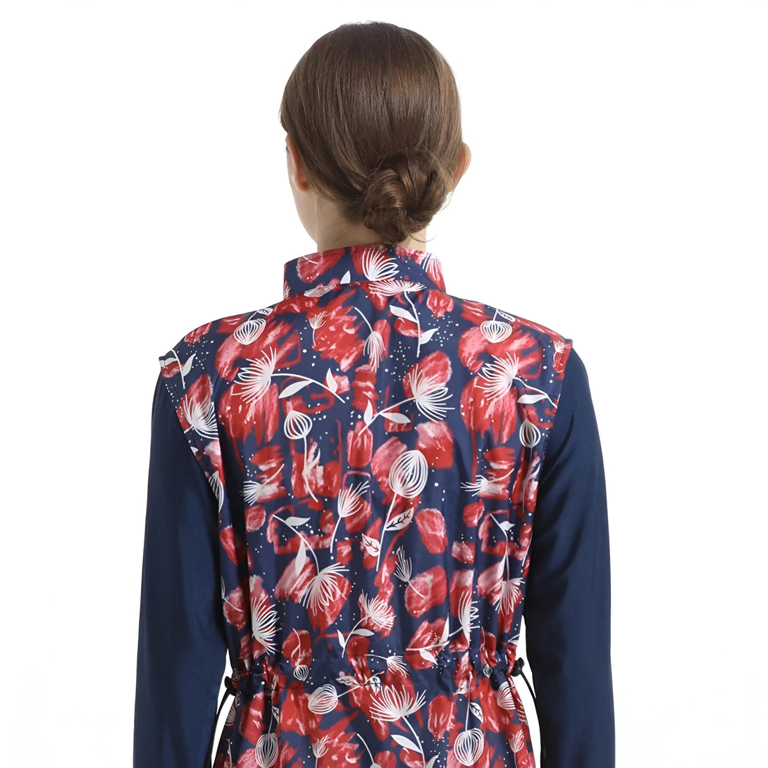 Vue arrière d'une veste sans manches à fleurs rouges et blanches sur un fond bleu marine.