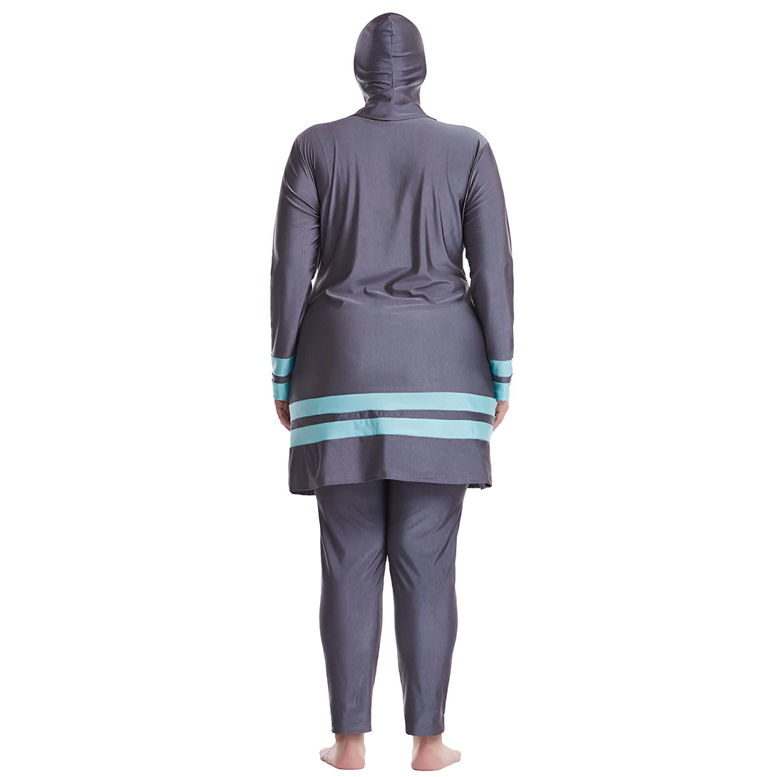 Une femme porte un maillot de bain musulman gris avec des bandes turquoise. Le maillot de bain est long et couvre tout le corps, y compris les bras et les jambes.