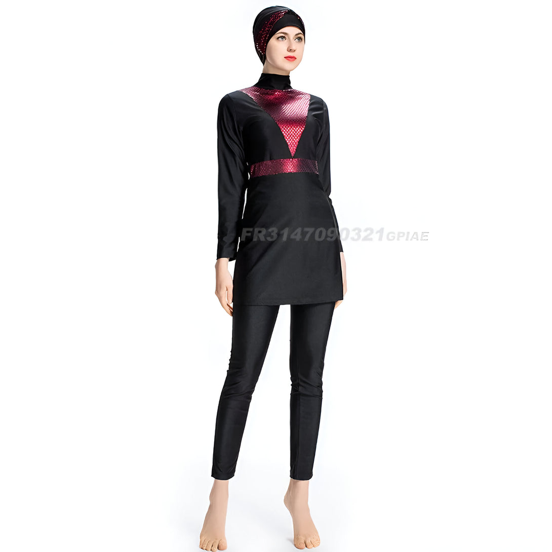Une femme portant un maillot de bain musulman noir avec un haut à manches longues et des pantalons. Le haut a une bande rouge et dorée sur le buste. La femme porte un hijab noir.