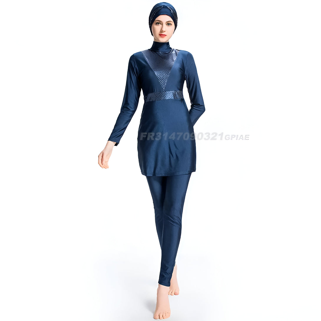 Une femme portant un maillot de bain musulman bleu avec un hijab assorti. Le maillot de bain est à manches longues et comprend un pantalon long. La femme se tient debout sur un fond blanc.