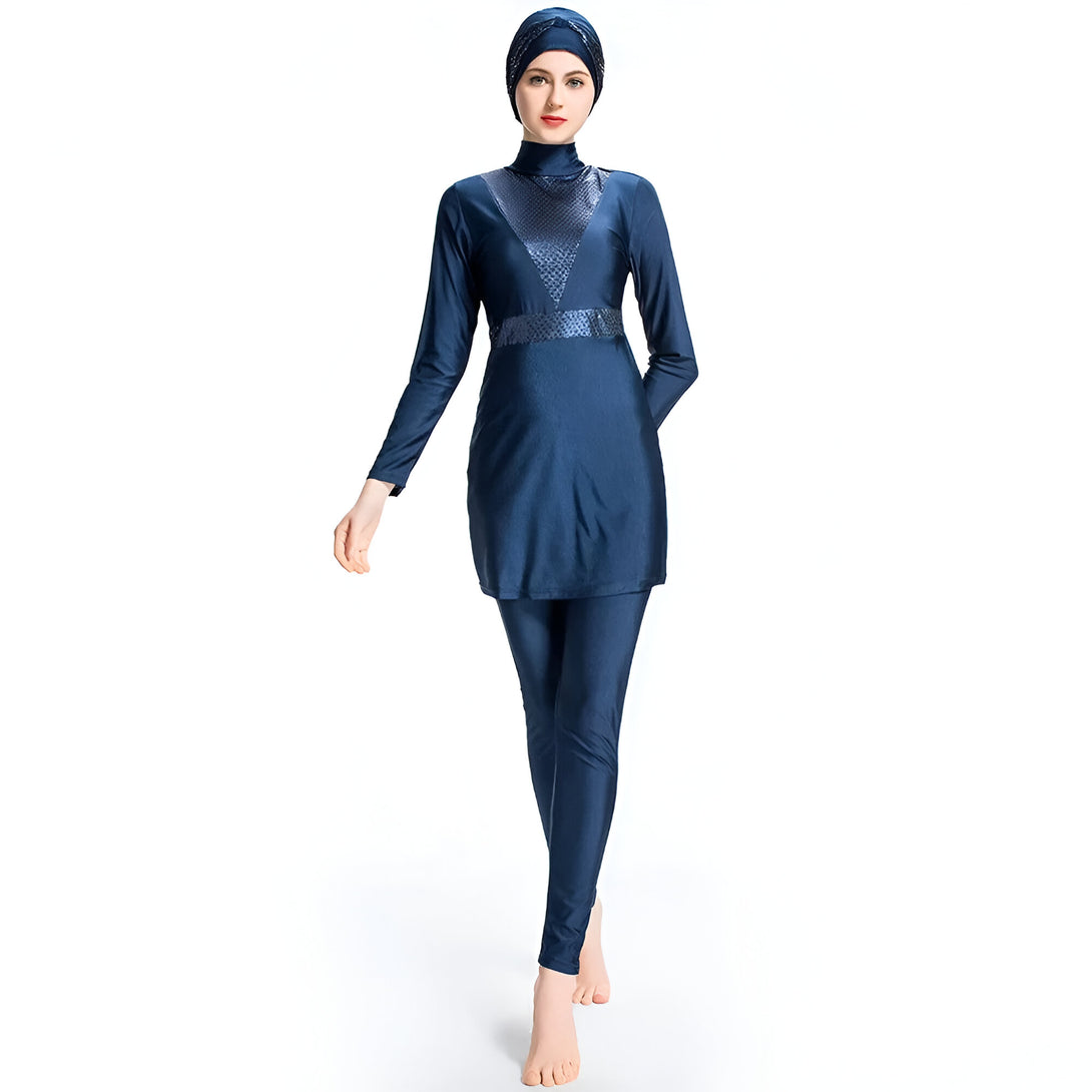 Une femme portant un maillot de bain musulman bleu foncé avec un hijab assorti. Le maillot de bain est à manches longues et comprend un pantalon long.