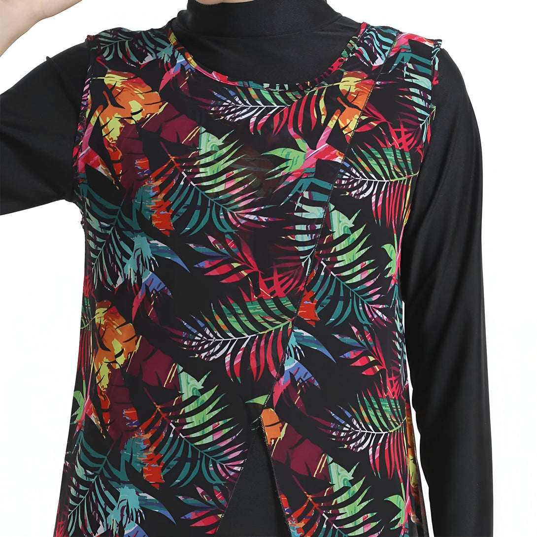 Une robe musulmane noire à manches longues avec un motif tropical coloré de feuilles sur le devant.