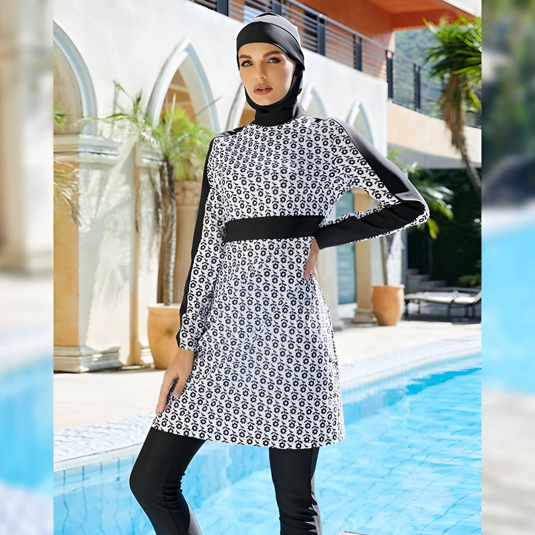 Une femme portant un maillot de bain musulman noir et blanc à fleurs près d'une piscine.