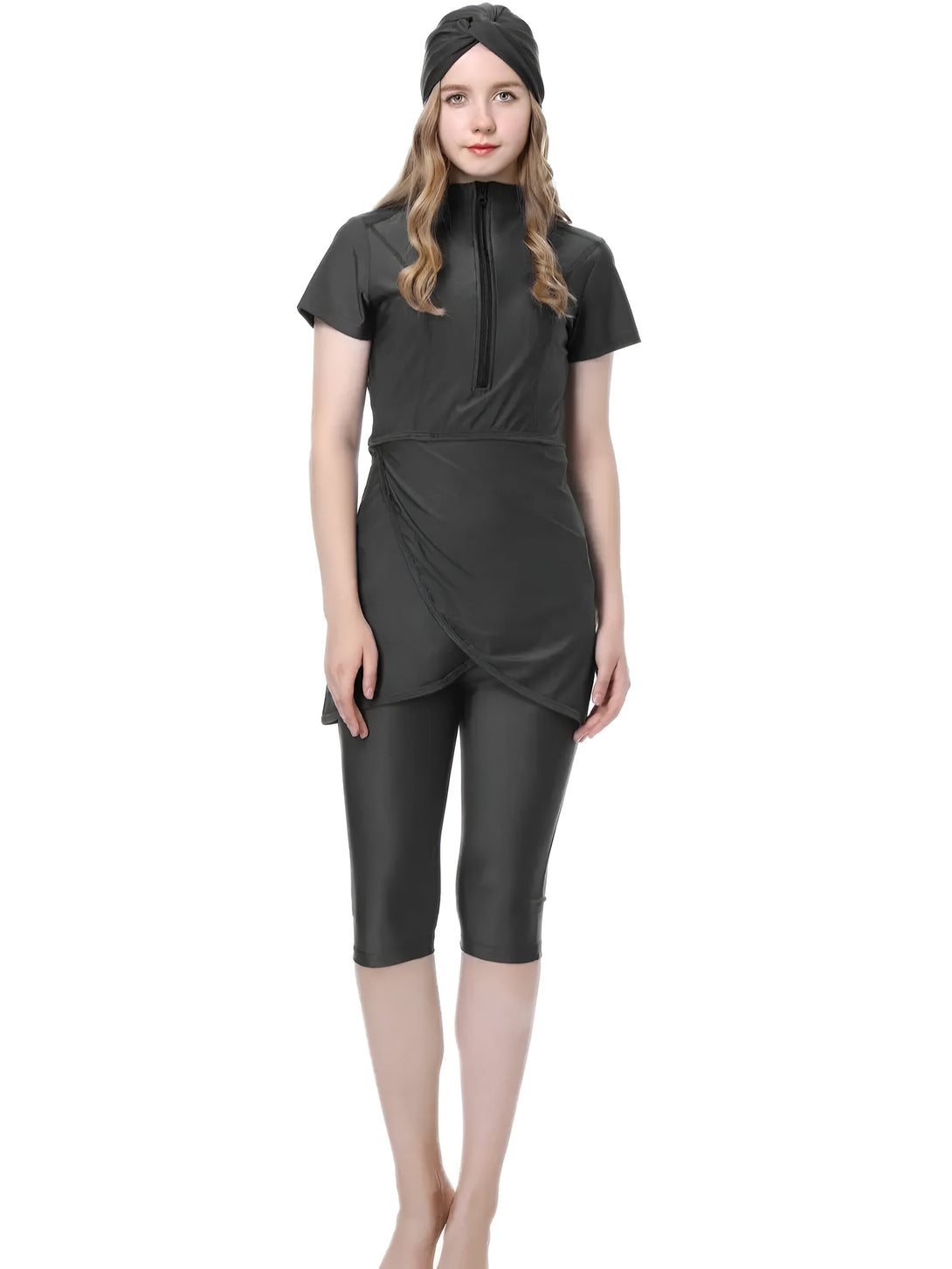 Une femme portant un hijab noir et un maillot de bain musulman noir avec une jupe intégrée.  Le maillot de bain est à manches courtes et comporte une fermeture éclair sur le devant.  Le pantalon est une longueur de capri.  Le maillot de bain est parfait pour nager et se bronzer tout en restant modeste.