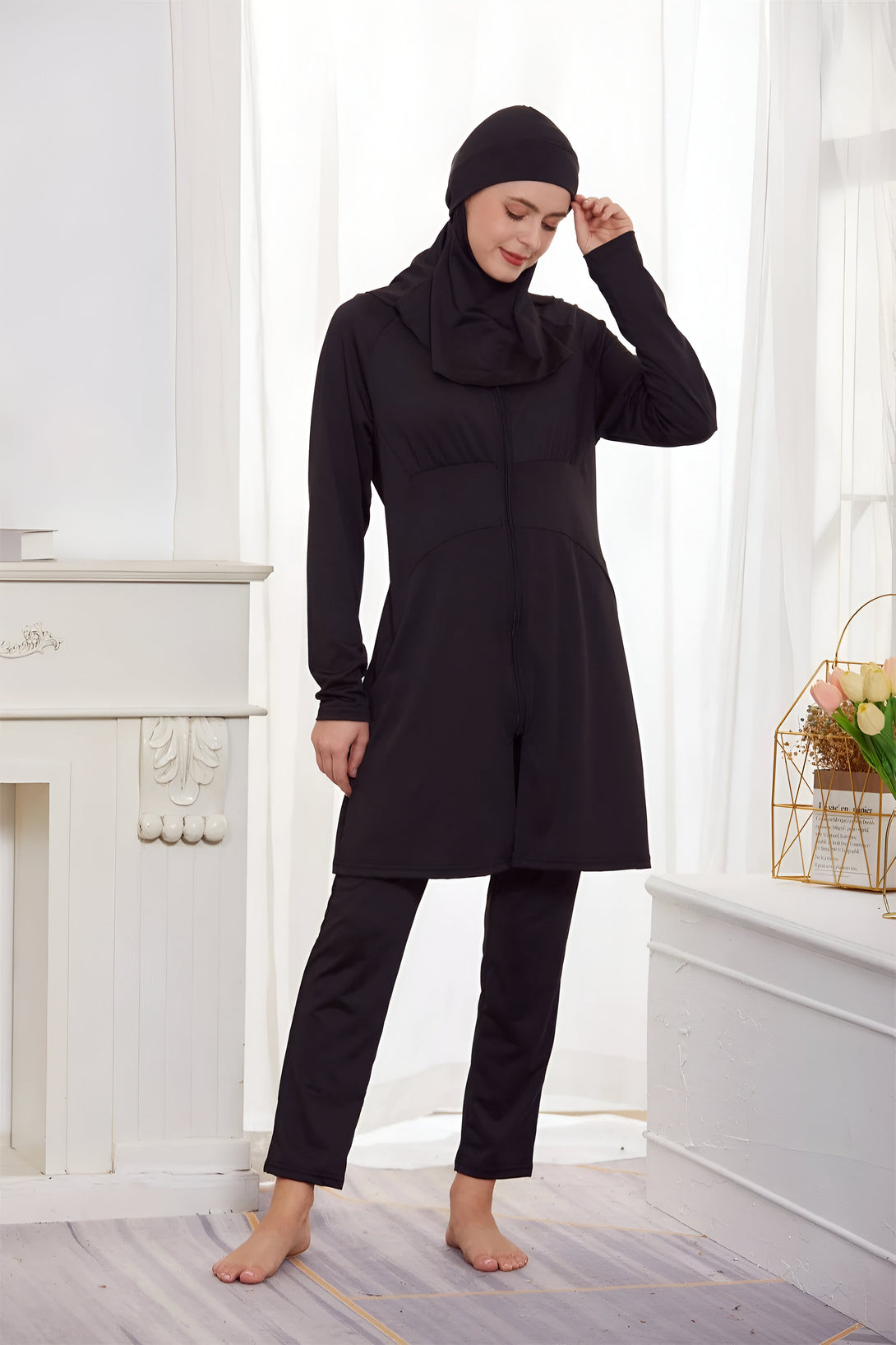 Une femme portant un maillot de bain musulman noir avec une longue tunique et un pantalon. Le maillot de bain est conçu pour offrir une couverture modeste tout en étant élégant et confortable.