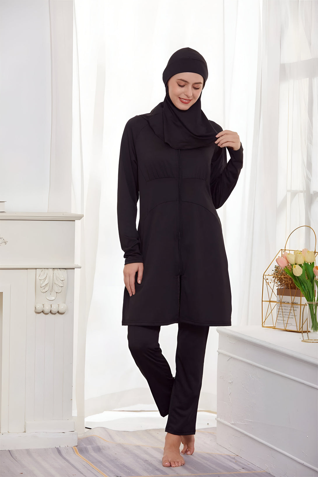 Une femme portant un maillot de bain musulman noir avec un pantalon assorti. La tenue est élégante et confortable, idéale pour la natation ou la plage.