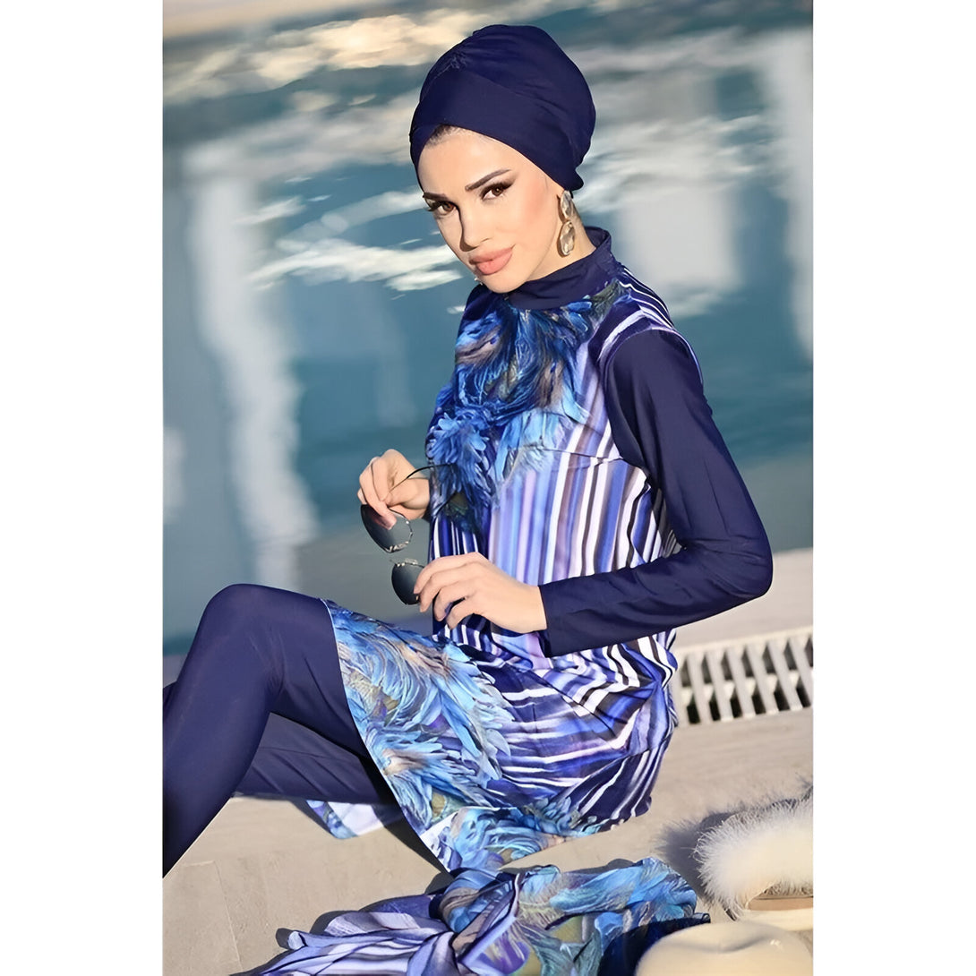 Une femme portant un hijab bleu foncé et un maillot de bain musulman bleu et blanc à motifs floraux. Elle porte également des lunettes de soleil.