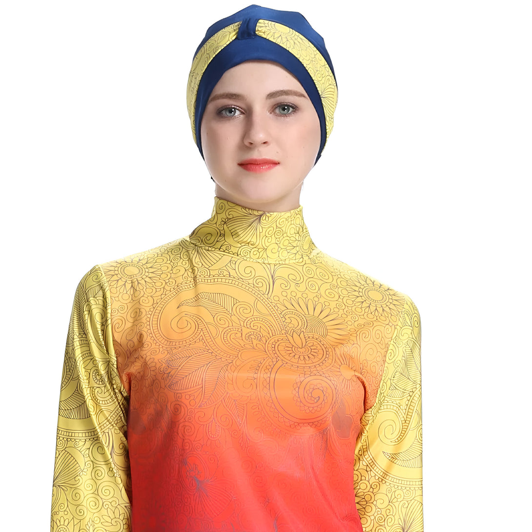 Une femme portant un maillot de bain musulman jaune et orange avec un motif floral et un bonnet bleu.