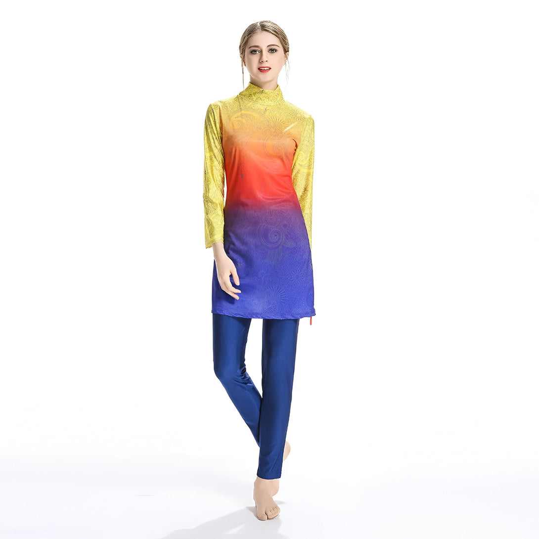 Une femme portant un maillot de bain musulman avec un haut jaune, orange et bleu et un pantalon bleu.