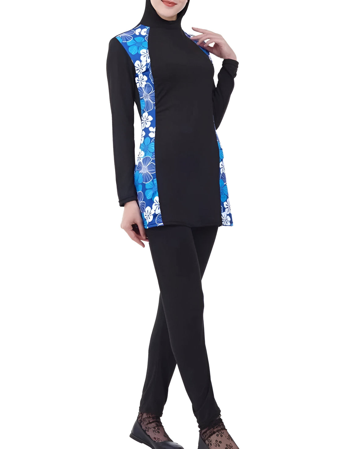 Une femme portant un maillot de bain musulman noir avec un motif floral bleu et blanc sur le côté.  Le maillot de bain est à manches longues et couvre les jambes.