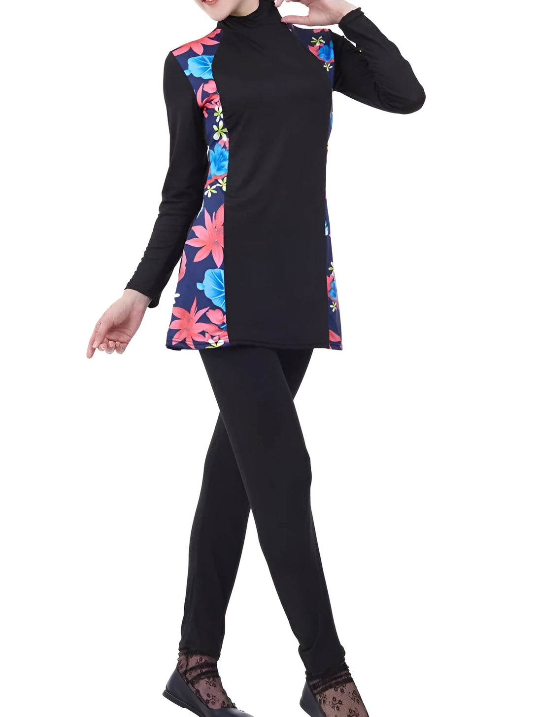 Une femme porte un maillot de bain musulman noir avec des motifs floraux bleus et roses. Le maillot de bain est à manches longues et couvre les jambes.