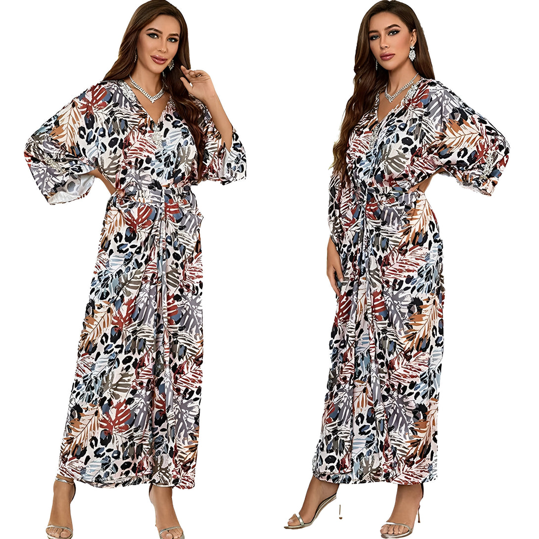 Deux femmes portant une longue robe musulmane à manches 3/4 avec un motif floral et animal. La robe est cintrée à la taille et a un col en V.