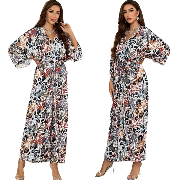Deux femmes portant une longue robe musulmane à manches 3/4 avec un motif floral et animal. La robe est cintrée à la taille et a un col en V.