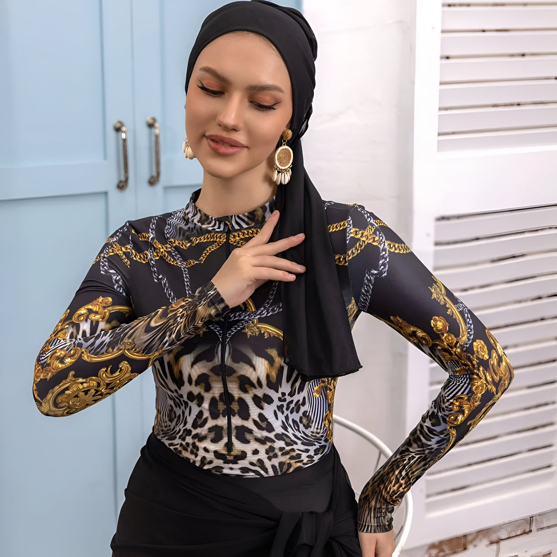 Une femme portant un hijab noir et un maillot de bain à manches longues avec un motif léopard et des chaînes dorées.