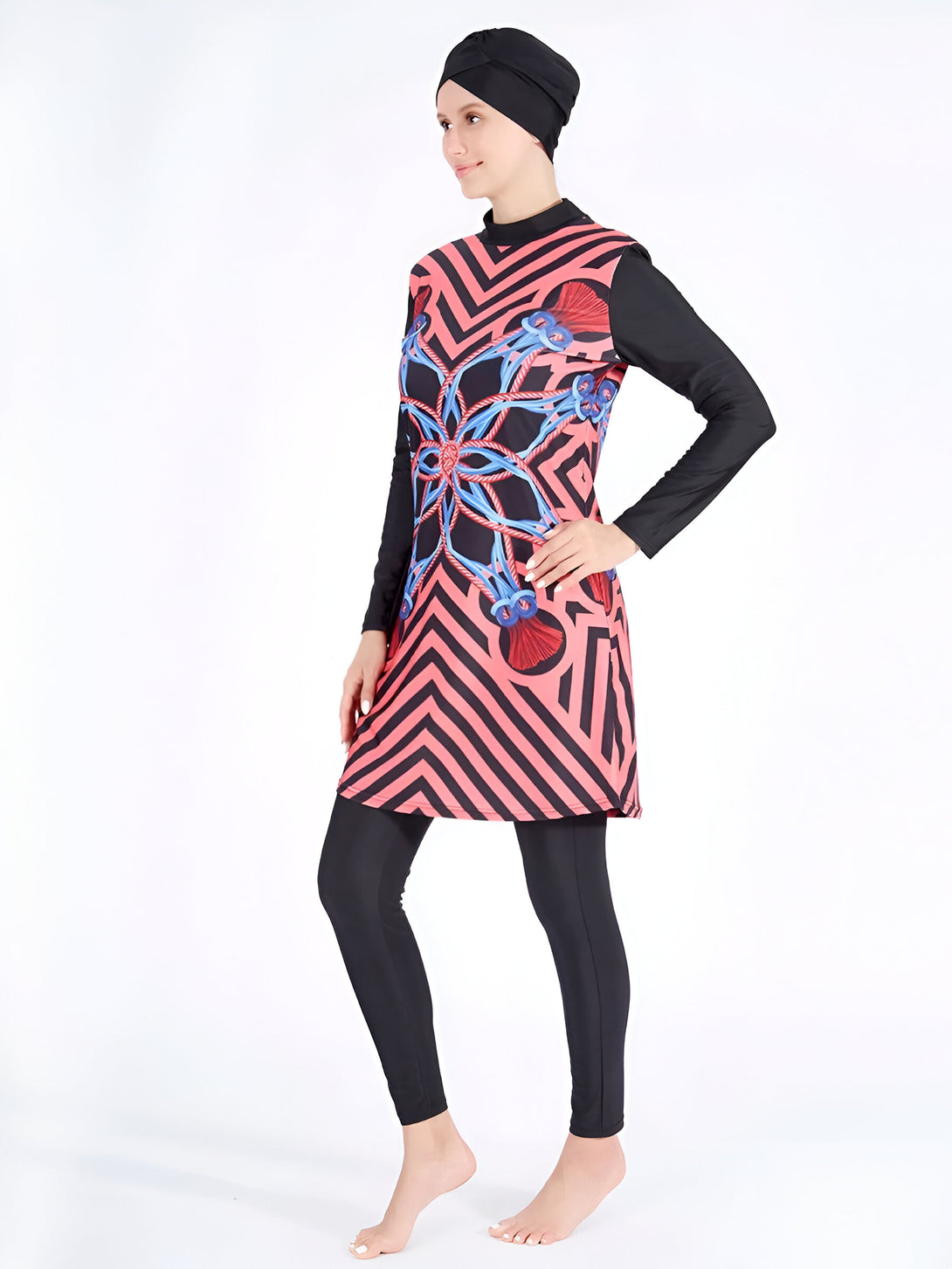 Une femme portant un maillot de bain islamique rose à rayures noires et un hijab noir. Le maillot de bain a un motif floral bleu.