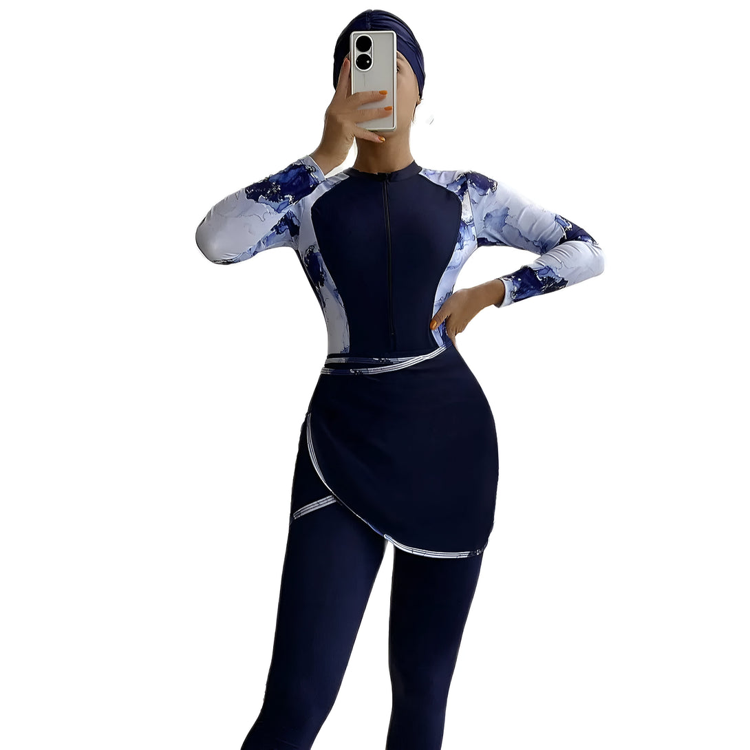 Une femme portant un maillot de bain musulman bleu marine avec un motif abstrait blanc. Elle porte également un hijab bleu marine.