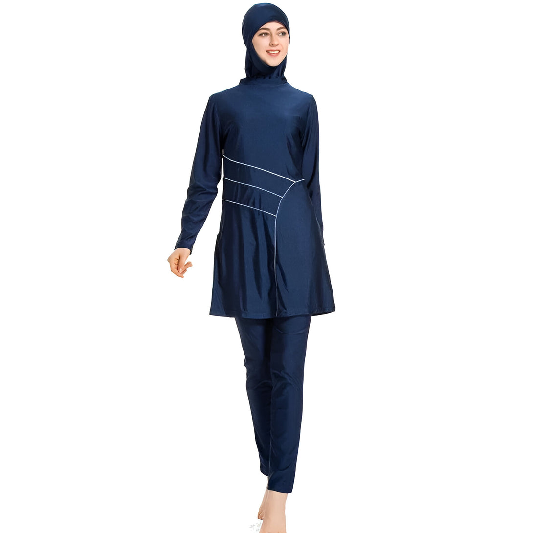 Une femme porte un maillot de bain islamique bleu foncé avec un hijab assorti. Le maillot de bain est à manches longues et comprend un pantalon long.  Il est idéal pour la natation et la plage.