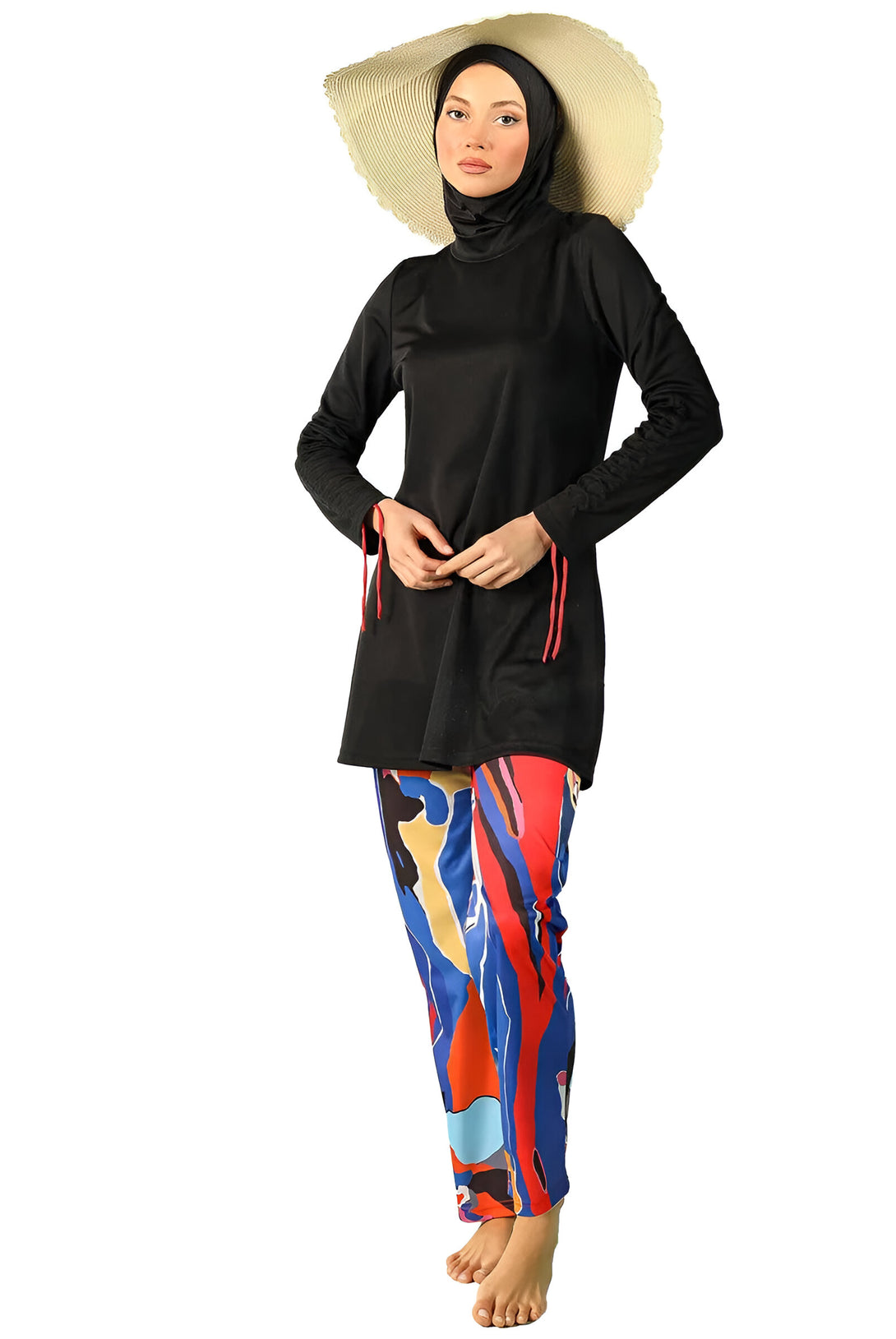 Une femme portant un maillot de bain musulman noir avec un pantalon imprimé coloré et un chapeau de paille.  #maillotdebainmusulman #tenuedeplage #modeislamique #modestfashion #vacances #ete #plage #maillotdebain #femme #style #élégant #tenue #accessoire #chapeau #paille #imprimé #coloré #noir #bleu #rouge #jaune #blanc