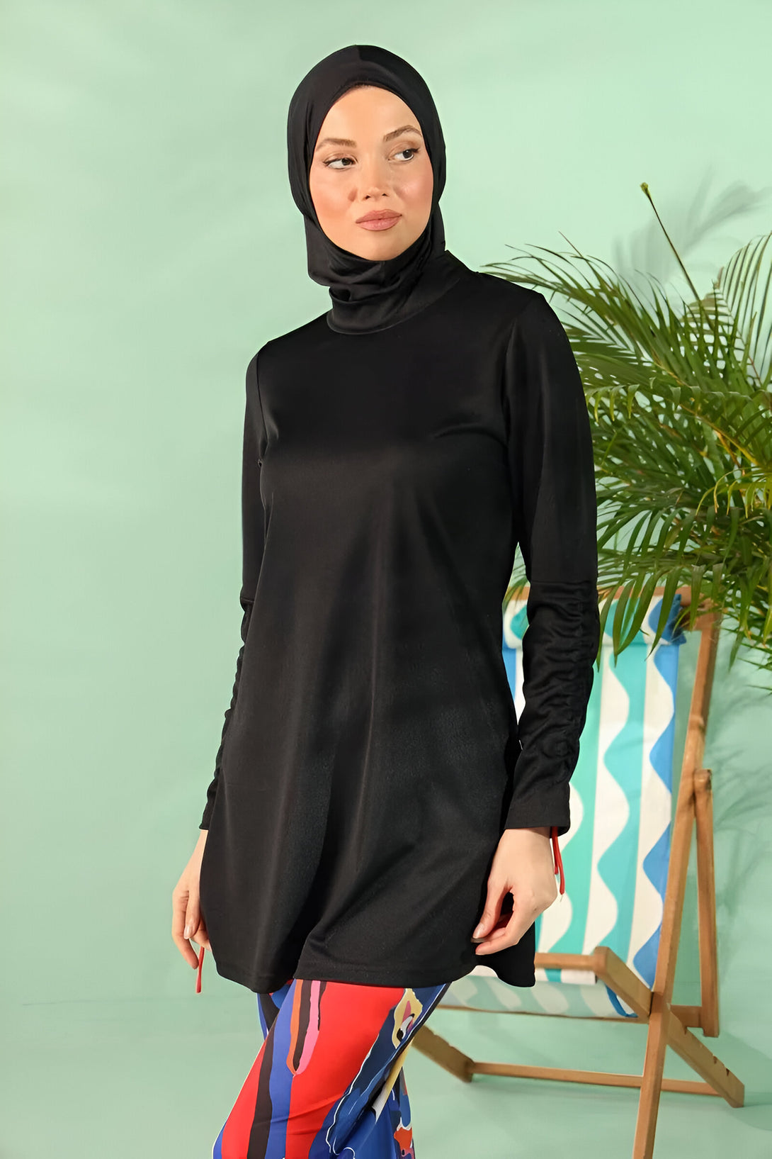 Une femme portant un hijab noir et une tenue de bain noire pour femmes musulmanes.