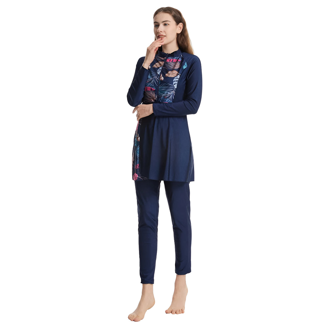 Une femme portant un maillot de bain islamique bleu marine à manches longues avec un motif floral. Le maillot de bain est composé d'une tunique et d'un pantalon.