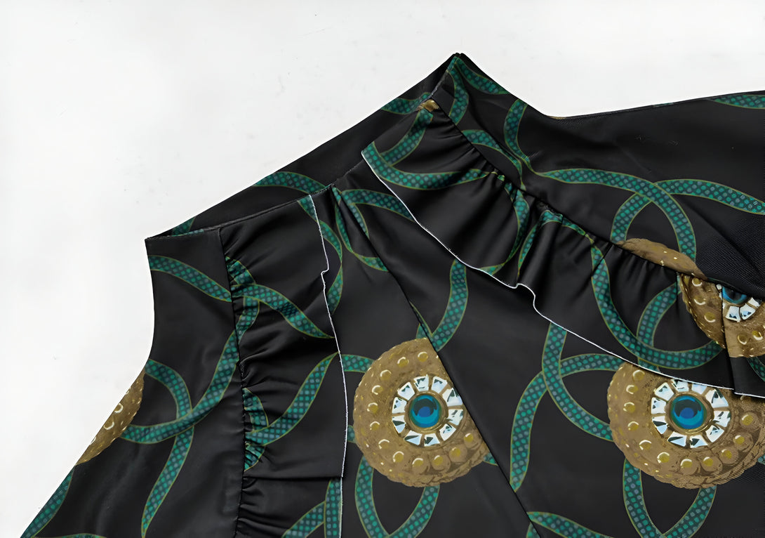 Détail du col d'une robe musulmane noire avec un motif de chaînes dorées et de cercles bleus.  Le col est orné de volants.  Découvrez notre collection de vêtements musulmans élégants.
